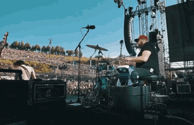 a man playing drums in front of a crowd that is watching a band perform