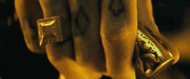 a close up of a person 's hand with a gold ring