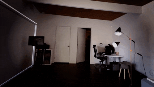 a dimly lit room with a desk and chair