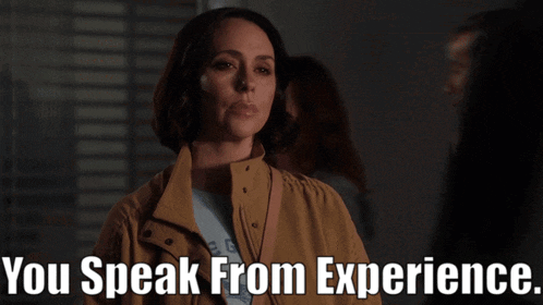 a woman in a brown jacket stands in front of a sign that says " you speak from experience "