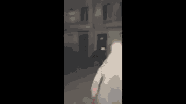 a blurry picture of a person walking in front of a building at night