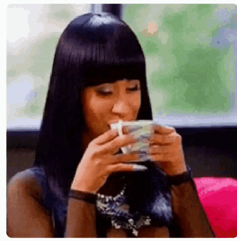 a woman is drinking a cup of coffee from a cup .