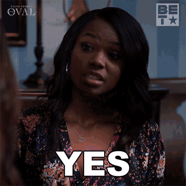 a woman in a floral dress is saying yes