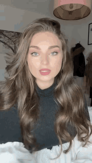 a woman with long hair is wearing a black turtleneck sweater