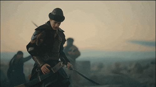 a man in armor holds a sword in front of a group of people