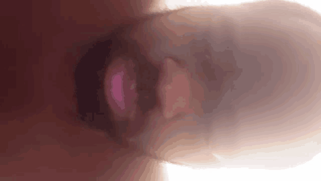 a close up of a man 's face with the sun shining through his hat