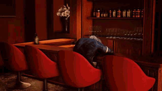 a man is sitting at a bar with his head on the bar
