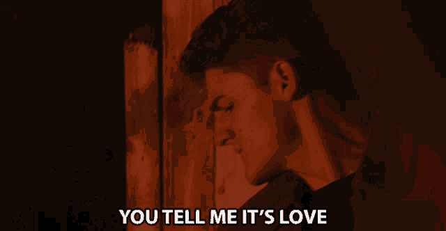 a man smoking a cigarette with the words " you tell me it 's love " above him