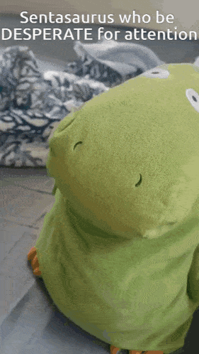 a green stuffed animal with the words sentasaurus who be desperate for attention on the bottom