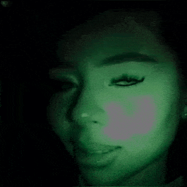a close up of a person 's face with a green light coming out of it .