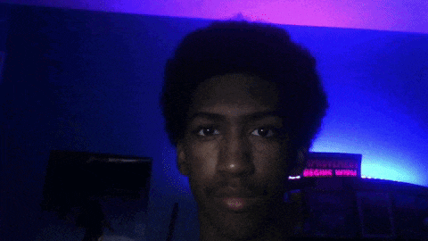 a blurry picture of a person 's face with purple and blue lights behind them .