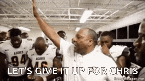 a man is giving a high five to a group of players in a locker room .