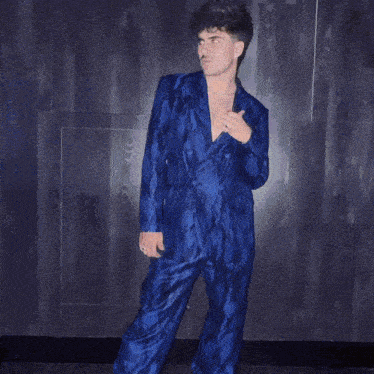 a man in a blue snakeskin jacket is standing next to another man
