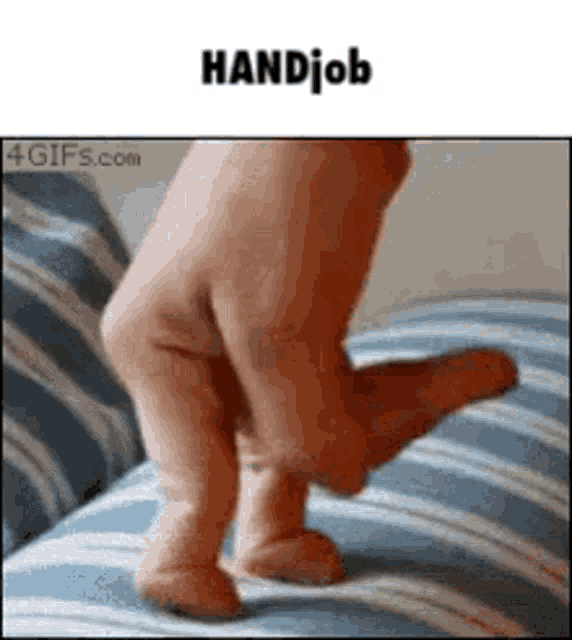 a person 's hand is holding a baby 's foot on a striped couch .