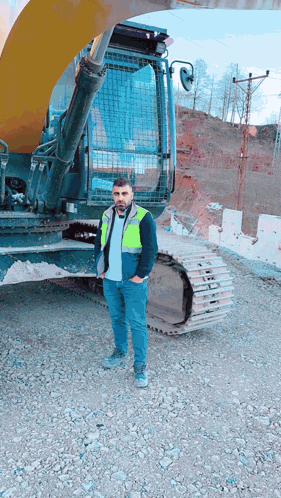 a man standing in front of a yellow excavator with the word volvo on it