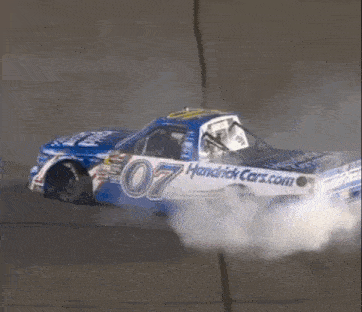 a race car with the number 07 on it is driving down a track .
