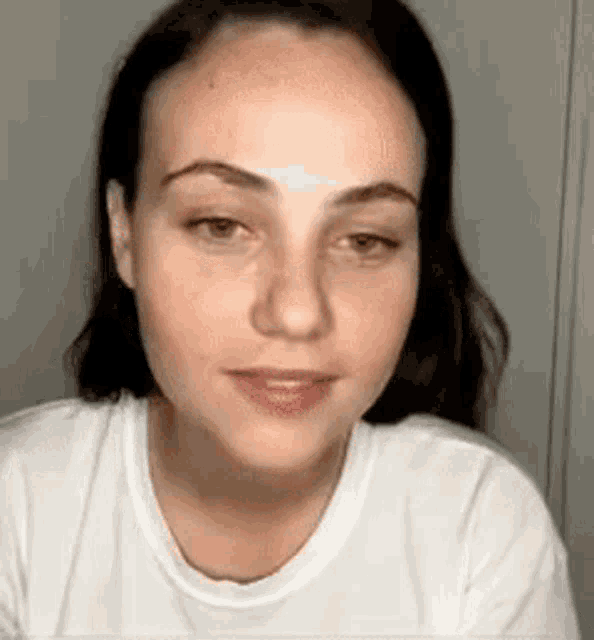 a close up of a woman wearing a white t-shirt .