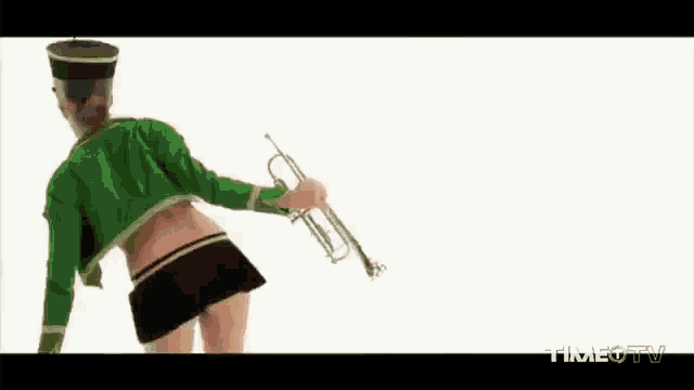 a woman in a green jacket is drinking from a glass while wearing a helmet .