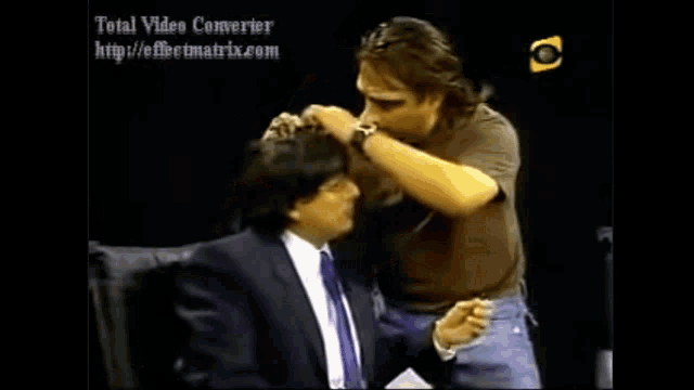 a man in a suit is being kissed by another man