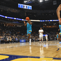 a basketball player is jumping in the air while holding a ball