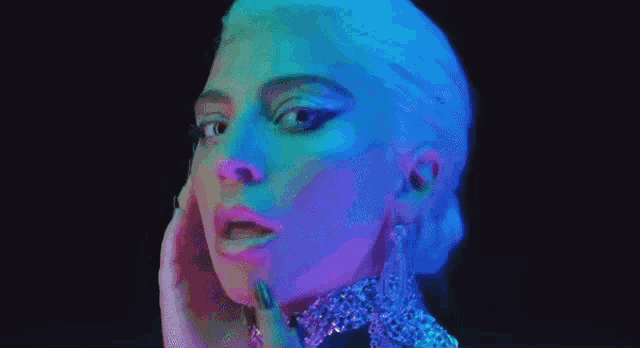 a close up of a woman 's face in a neon light with her tongue out .