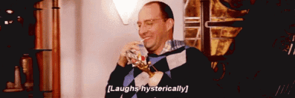 a man with glasses is drinking through a straw and says laughs hysterically