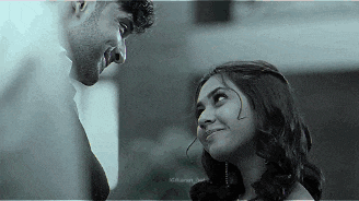 a man and a woman are looking at each other and smiling .