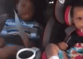 a baby is sitting in a car seat next to a person .