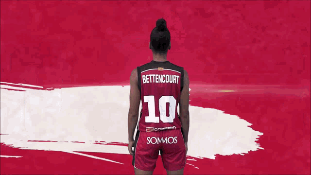 a woman in a basketball uniform stands in front of a red and white background with the word trole written on it