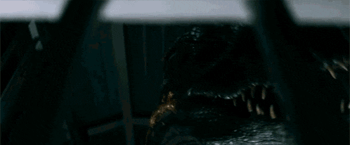 a close up of a monster 's mouth and teeth in a dark room
