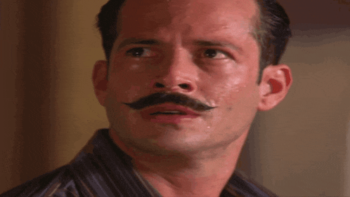 a man with a mustache is looking at something