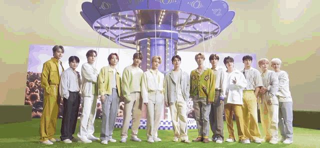 a group of young men are standing in front of a ferris wheel .