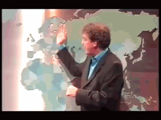 a man in a suit is standing in front of a world map