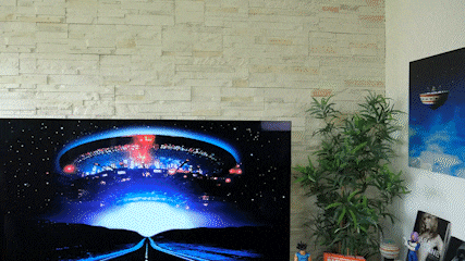 a flat screen tv shows a picture of an alien landing