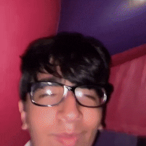 a close up of a person wearing glasses with a pink background