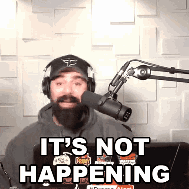 a man with a beard and headphones says it 's not happening in front of a microphone