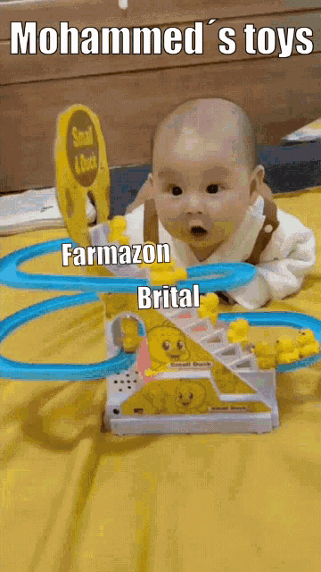 a baby laying on a bed next to a toy that says farmazon brital