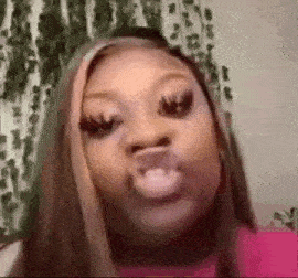 a woman is blowing a kiss with her mouth open and making a funny face .
