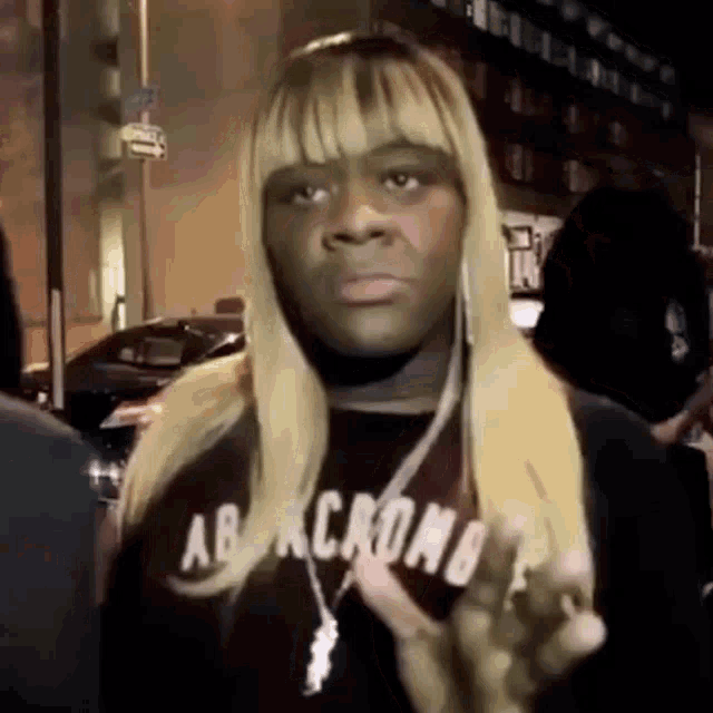 a woman with blonde hair is wearing a black abercrombie shirt .