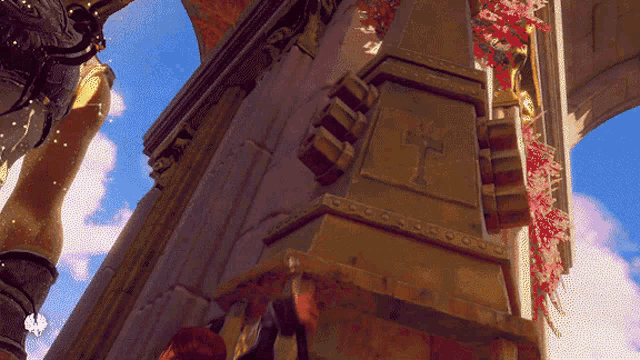 a pillar with a cross on it is surrounded by flowers