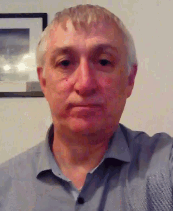 a man taking a selfie in front of a framed picture on the wall