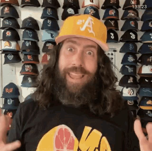 a man with long hair and a beard wearing a hat with the letter a on it
