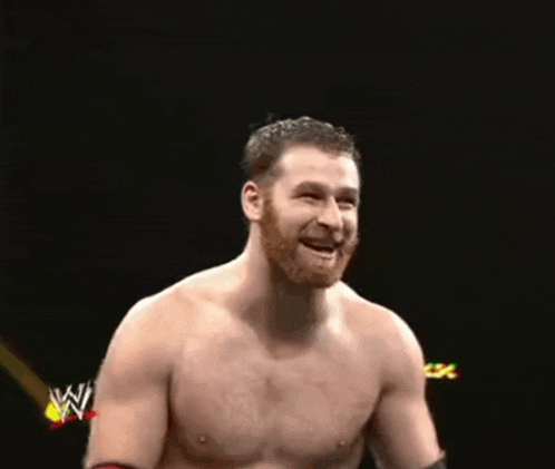 a shirtless wrestler is smiling in front of a black background