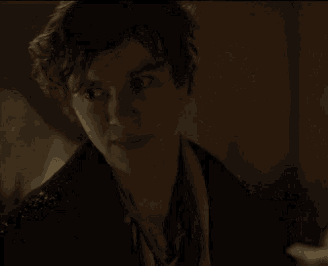 a close up of a young man 's face in a dark room .