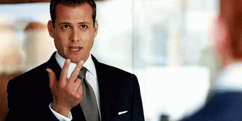 a man in a suit and tie is giving a peace sign .