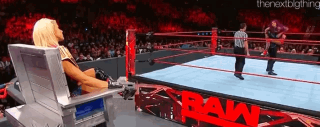 a woman sits in a chair in a wrestling ring with the word raw on the side