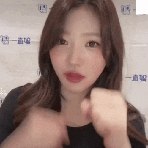 a young woman is making a fist with her hands .