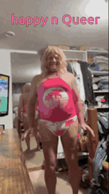 a man in pink underwear is standing in front of a mirror with the words happy n queer written above him