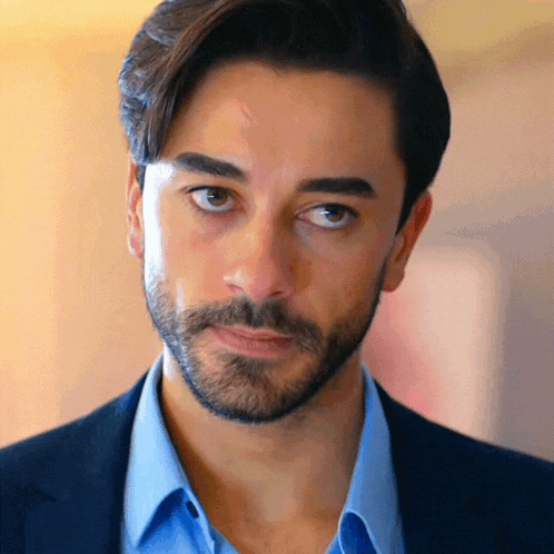 a man with a beard is wearing a blue shirt and a suit