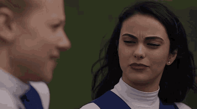 a man and a woman are standing next to each other and the woman is making a face